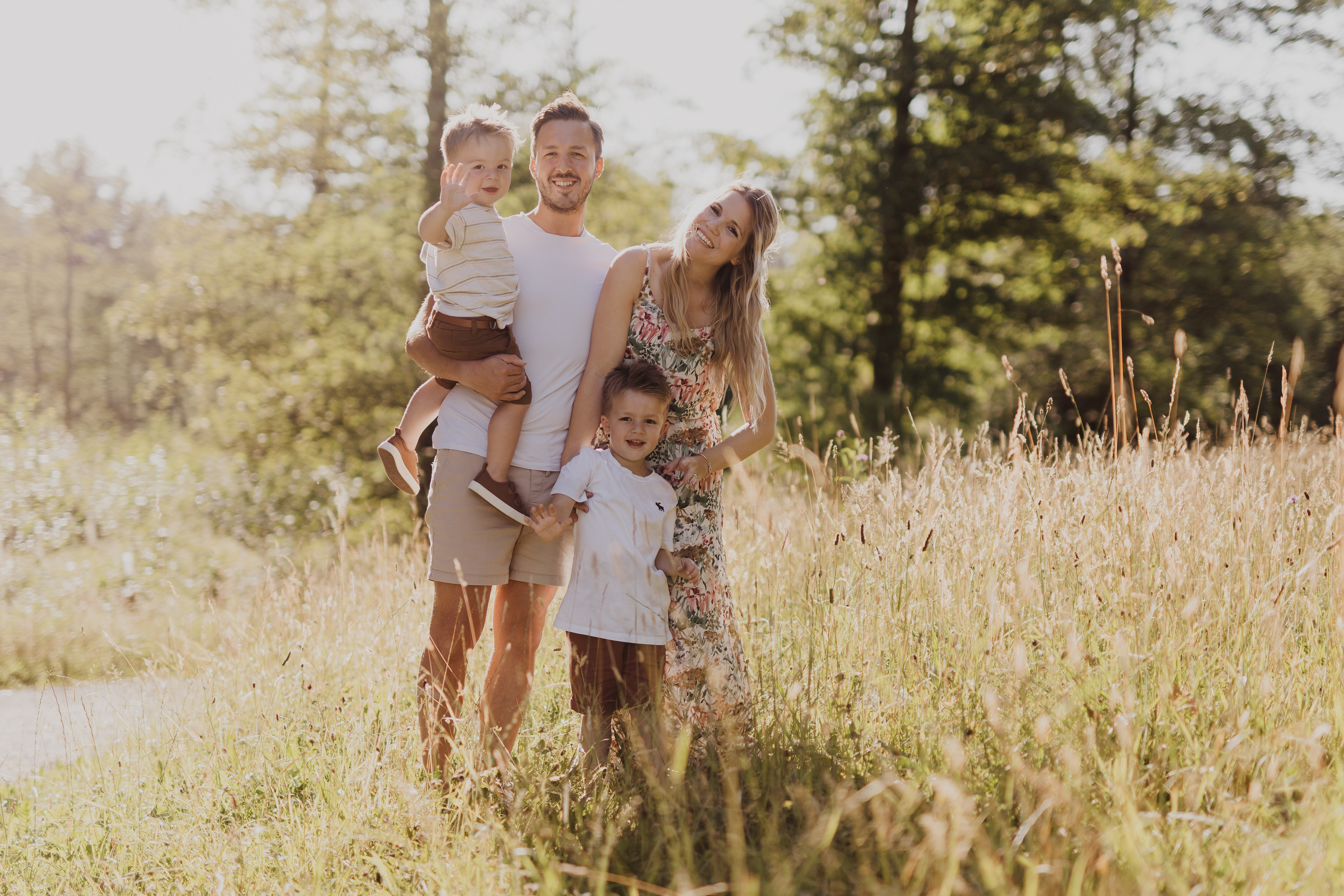 Während eines Familyshootings steht hier eine junge Familie mitten in der Natur auf einem Feld. Die Fotografin hat die Charaktere der Kinder perfekt eingefangen bei diesem Fotoshooting.