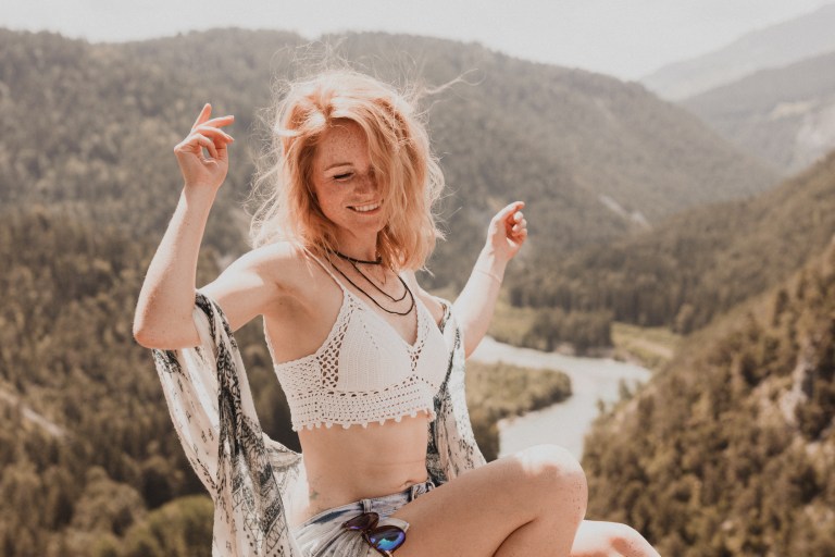 Eine rothaarige Frau tanzt ausgelassen während eines Fotoshootings, bei dem natürliche und authentische Aufnahmen der jungen frau entstehen.